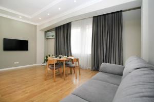 una sala de estar con un sofá y una mesa en Perfect spacious apartment 365, en Almaty