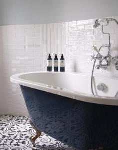 a bath tub with two bottles on it in a bathroom at Stanwell House in Lymington