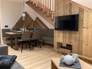 un soggiorno con TV e tavolo con divano di das MARX - Gasthof Marx - Apartments a Grosskirchheim