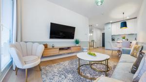 a living room with a couch and a tv at Apartament Lux Tukan B005 Polanki Aqua - Holiday City in Kołobrzeg
