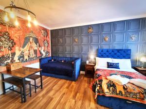 a bedroom with a blue bed and a blue couch at Ricky Road Guest House - "Wizard Studio Room" Available to Book Now in Watford