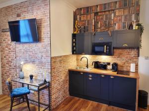 cocina con fregadero y pared de ladrillo en Ricky Road Guest House - "Wizard Studio Room" Available to Book Now, en Watford