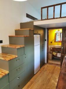 a kitchen with green cabinets and a white refrigerator at Tiny House in Garden with Sea View in Karamusal