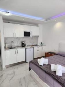 1 dormitorio con 1 cama y cocina con armarios blancos en Jameo de agua, las americas studio sea view, en Playa Fañabe