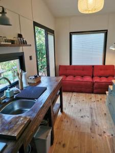 cocina con sofá rojo en una habitación en Tiny House in Garden with Sea View, en Karamusal