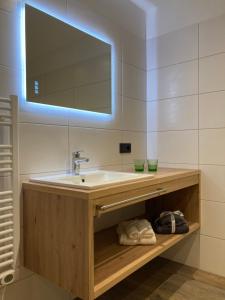 a bathroom with a sink and a mirror at das MARX - Gasthof Marx - Apartments in Großkirchheim