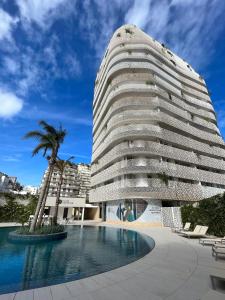 a tall building with a swimming pool in front of it at Joumaya White & See in Casablanca