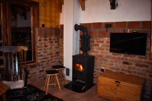 a stove in a room with a tv and a fireplace at Vikendica Tromedja Pale in Pale