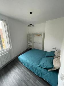 um quarto com uma cama verde num quarto branco em Maison face à l'eglise em Toucy
