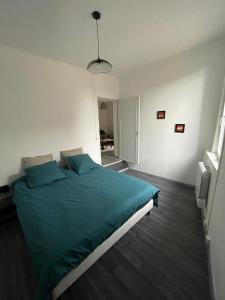 um quarto com uma cama grande e almofadas azuis em Maison face à l'eglise em Toucy