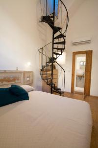 a bedroom with a bed and a spiral staircase at VelaCatania rooms in Catania