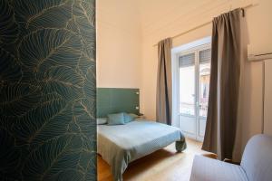 カターニアにあるVelaCatania roomsの緑豊かな壁紙のベッド1台が備わるベッドルーム1室が備わります。