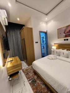 um quarto com uma cama, uma secretária e uma televisão em Bricks Residence em Lekki