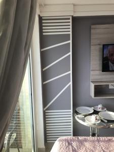 a room with a table and a wall with stripes at Flat Beira Mar de Intermares in Cabedelo