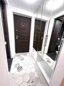 a bathroom with a black door and a tiled floor at Studio Enis in Poiana Brasov