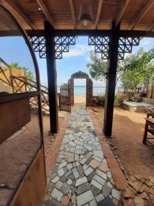 an open structure with a stone walkway leading to the beach at SHANTY HOUSE Apartment in Dahab