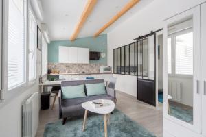 a living room with a couch and a table at L'Émeraude in Malesherbes