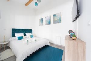 ein Schlafzimmer mit einem großen Bett mit einem blauen Teppich in der Unterkunft L'Émeraude in Malesherbes