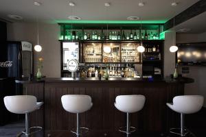 un bar avec des tabourets blancs dans une pièce dans l'établissement Villa Silva - Oberhof, à Oberhof