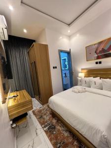 1 dormitorio con 1 cama blanca grande y escritorio en Bricks Residence, en Lekki