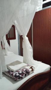 un letto con tende bianche e un libro sopra di Ayawaska Atractivo Sacha Wasi a Nueva Loja