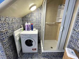 a bathroom with a washing machine and a shower at Mid Modern Akragas Home in Center with Sea View in Agrigento +28 photos