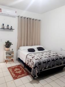 a bedroom with a bed with a black and white comforter at Pousada Mar & Sol in Fortaleza
