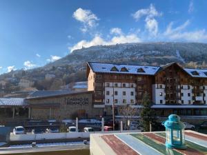 a large building with a mountain in the background at La Kaz montagne in Briançon