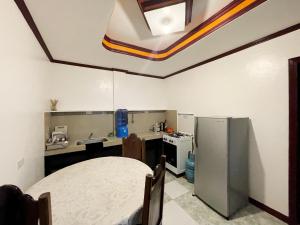 a kitchen with a sink and a refrigerator at Lara's Guesthouse Siargao in General Luna