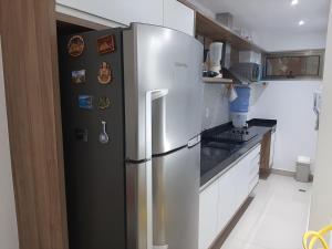 una nevera de acero inoxidable en una cocina en Flat com vista panorâmica na melhor localização, en Natal