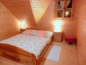 a bedroom with a bed in a wooden cabin at Liptovská Drevenica in Liptovský Mikuláš