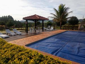 a swimming pool with a gazebo and a table and chairs at POUSADA SAKURA in Patrimônio São Sebastião