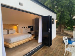 a bedroom with a bed and a sliding glass door at The Log Cabin Lodge in Stellenbosch