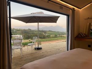 a bedroom with a view of a patio with an umbrella at The Log Cabin Lodge in Stellenbosch