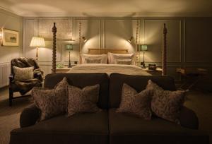 a bedroom with a bed and a couch with pillows at Stanwell House in Lymington