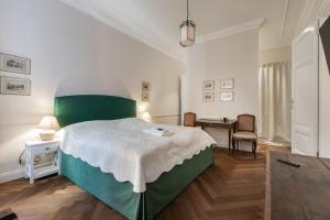 - une chambre avec un grand lit vert et un bureau dans l'établissement Noble Luxurious Palais, à Vienne
