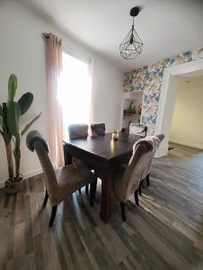 a dining room with a wooden table and chairs at Jacuzzi privatif - Suite Amazonie - 1 ou 2 chambres in Chaumes-en-Brie