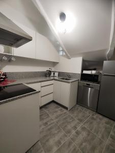 a kitchen with white cabinets and a stove top oven at Jacuzzi privatif - Suite Amazonie - 1 ou 2 chambres in Chaumes-en-Brie