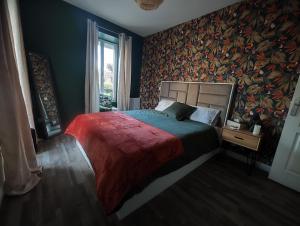 a bedroom with a large bed with a colorful wall at Jacuzzi privatif - Suite Amazonie - 1 ou 2 chambres in Chaumes-en-Brie