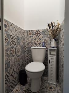 a bathroom with a toilet and a tiled wall at Jacuzzi privatif - Suite Amazonie - 1 ou 2 chambres in Chaumes-en-Brie