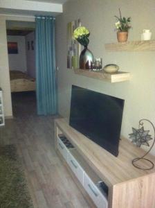 a living room with a flat screen tv on a table at Appartement Ursula Eck in Bergisch Gladbach +2 photos