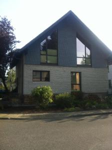 une maison en briques avec des fenêtres donnant sur une rue dans l'établissement Appartement Ursula Eck, à Bergisch Gladbach