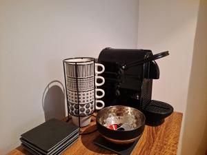 Boigne Sweet Suite في شامبيري: آلة صنع القهوة ووعاء على طاولة خشبية
