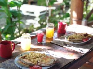 a wooden table with two plates of food and drinks at Samana Ecolodge in El Limón