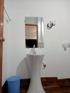 a bathroom with a white sink and a mirror at Riya Cottages and Beach Huts in Agonda
