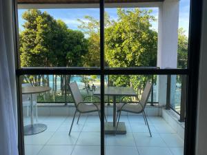 einen Balkon mit einem Tisch und Stühlen sowie einem Fenster in der Unterkunft Iloa Resort in Barra de São Miguel