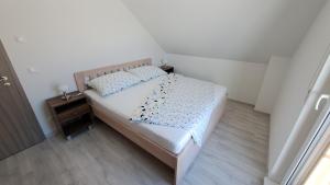 a small bedroom with a bed and a night stand at Domeček pod skalami, Tisá 535 in Tisá