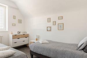 Sainte-Croix-en-PlaineAPPARTEMENT climatisé 70 m2, proximité de COLMAR的一间白色卧室,配有两张床和梳妆台