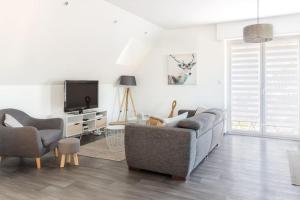 Sainte-Croix-en-PlaineAPPARTEMENT climatisé 70 m2, proximité de COLMAR的客厅里有一张沙发和一台电视