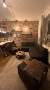 sala de estar con sofá y pared de ladrillo en Sanierte Wohnung mit Balkon im Hochparterre en Hannover
